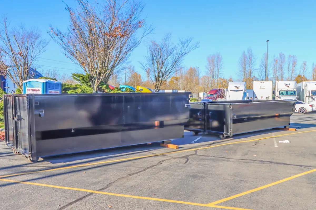 Professional dumpster rental service with roll-off container on residential driveway in Raceland